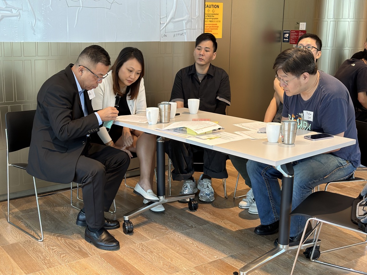 Wide shot of full workshop — participants collaborating in circle