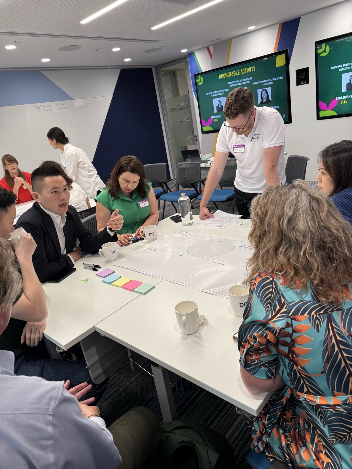 Workshop participants engaged in roundtable activity with post-it notes